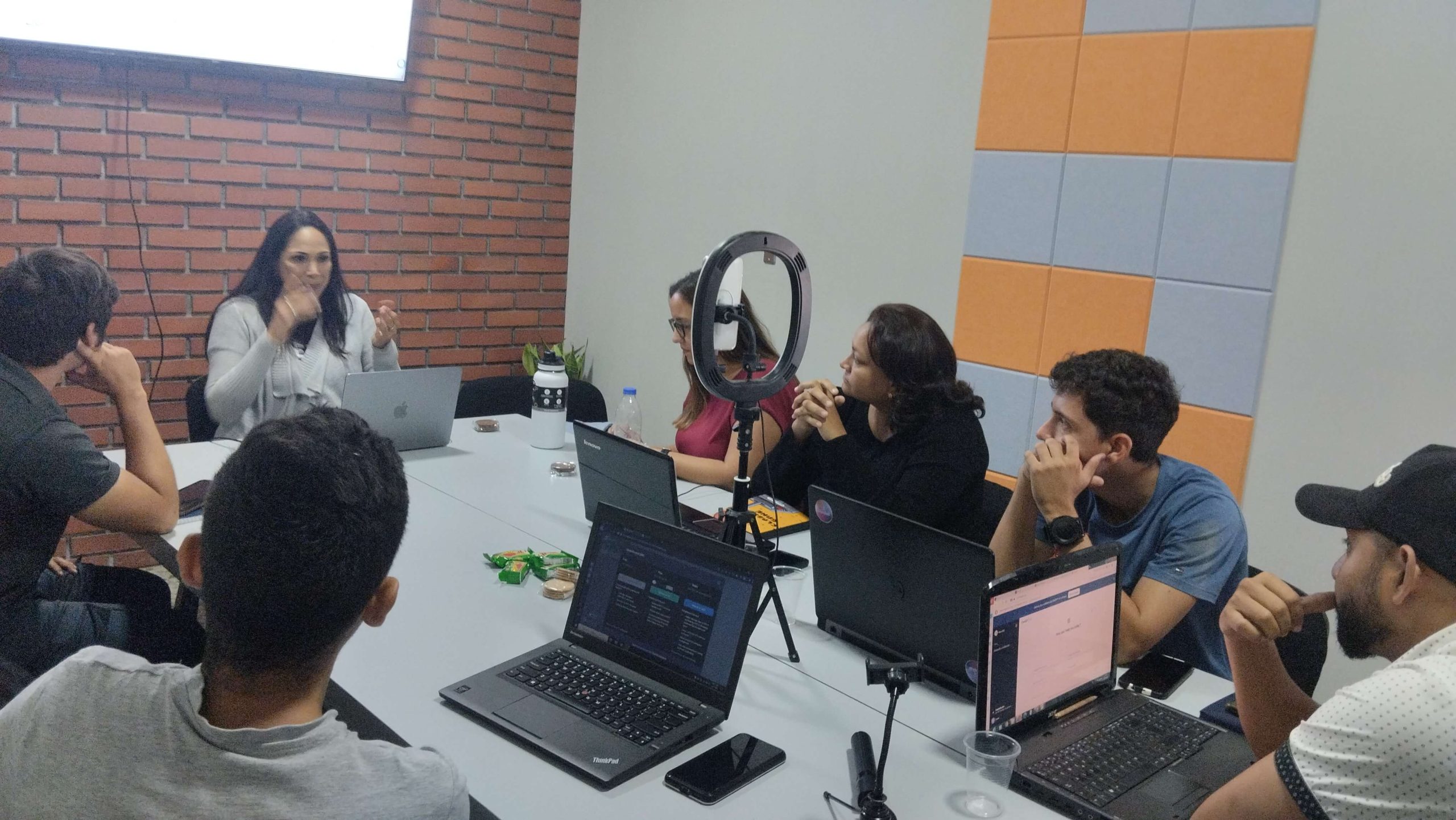 Grupo de personas participando en un taller de Marlin Duran sobre ChatGPT en español, con laptops abiertos y atención centrada en la oradora principal"