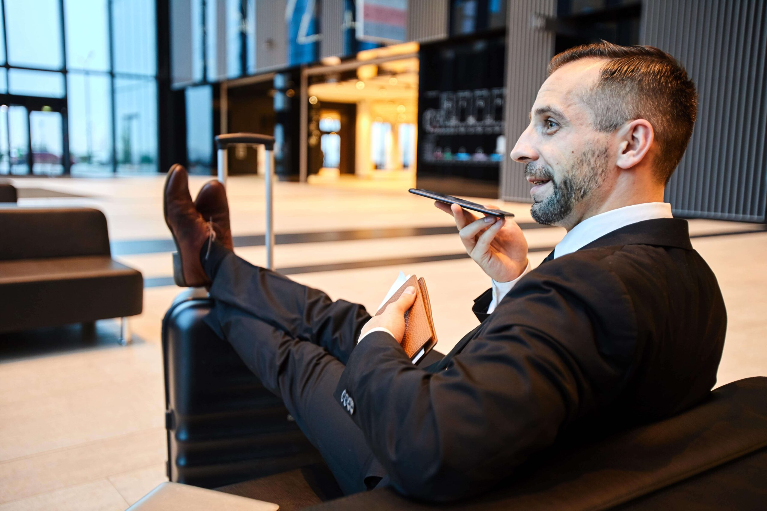 Hombre de negocios usando su teléfono para interactuar con su agente de IA, construído con ChatGPT
